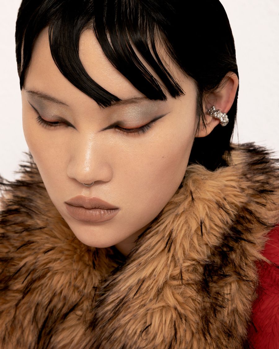 Close-up beauty portrait with graphic eye liner, sleek hair and a fur collar