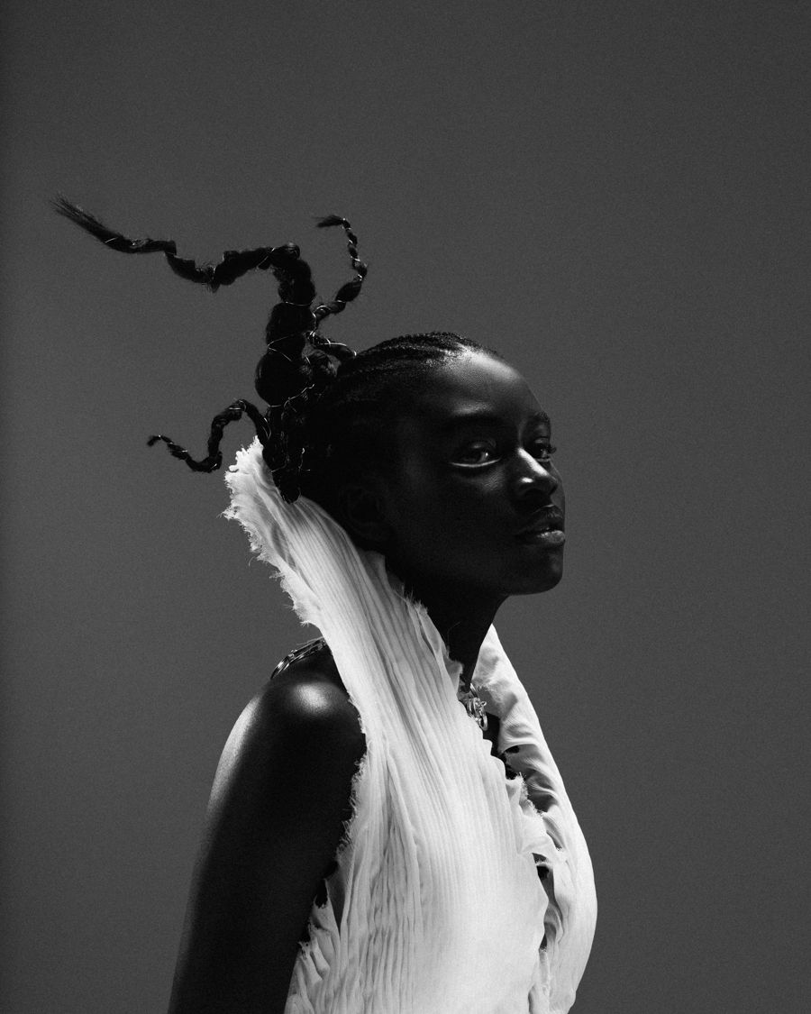 Profile portrait with sculptural braided hair and a white pleated collar